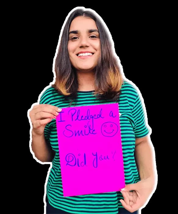 An intern holding her handwritten pledge sign